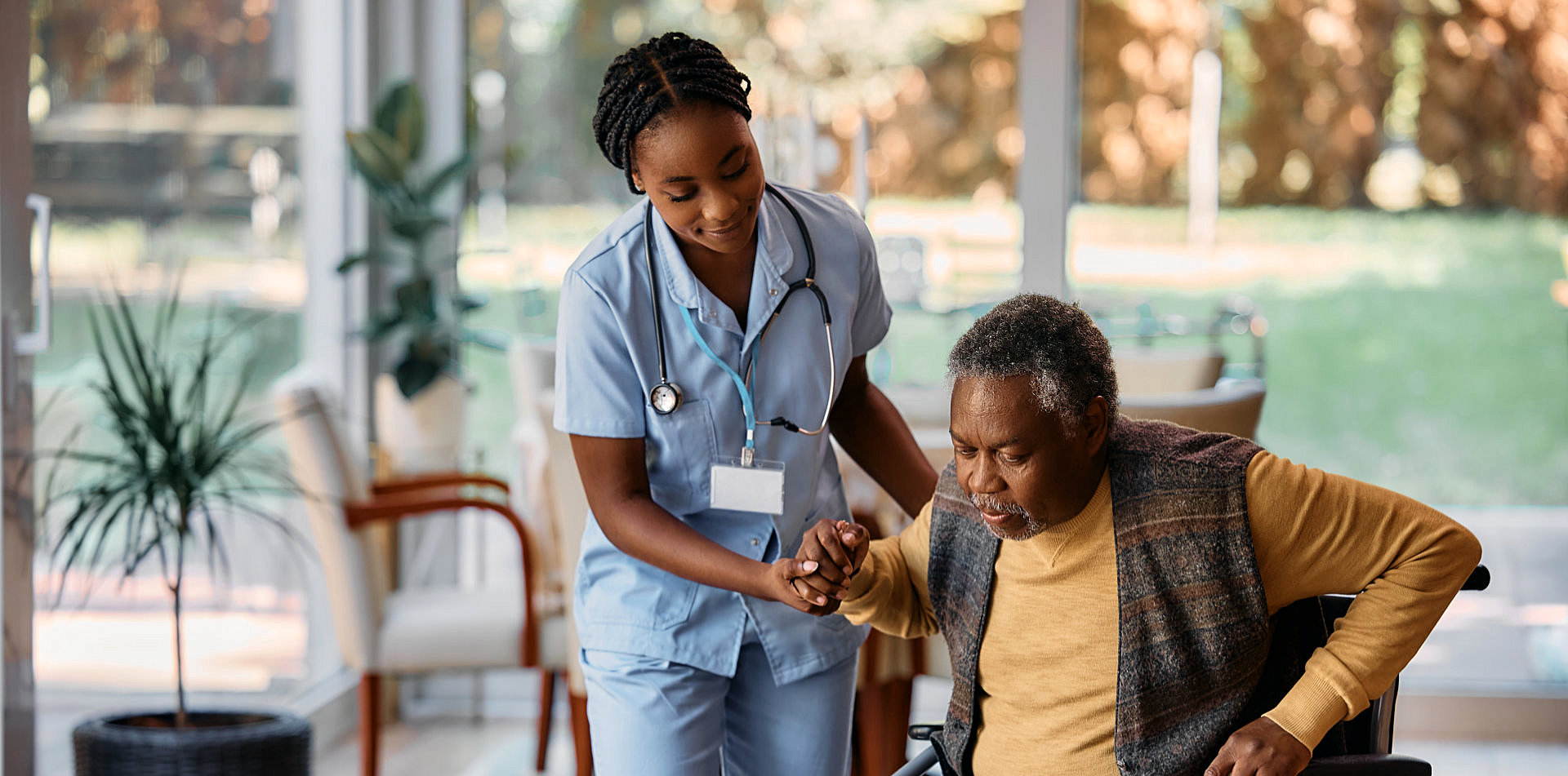 Nurse is helping senior man to get up