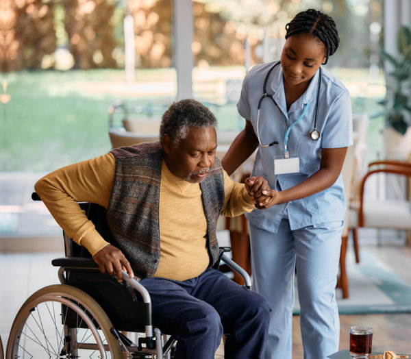 Nurse is helping senior man to get up