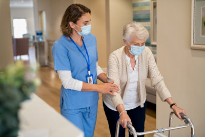 Nurse woman is guiding senior woman to walk