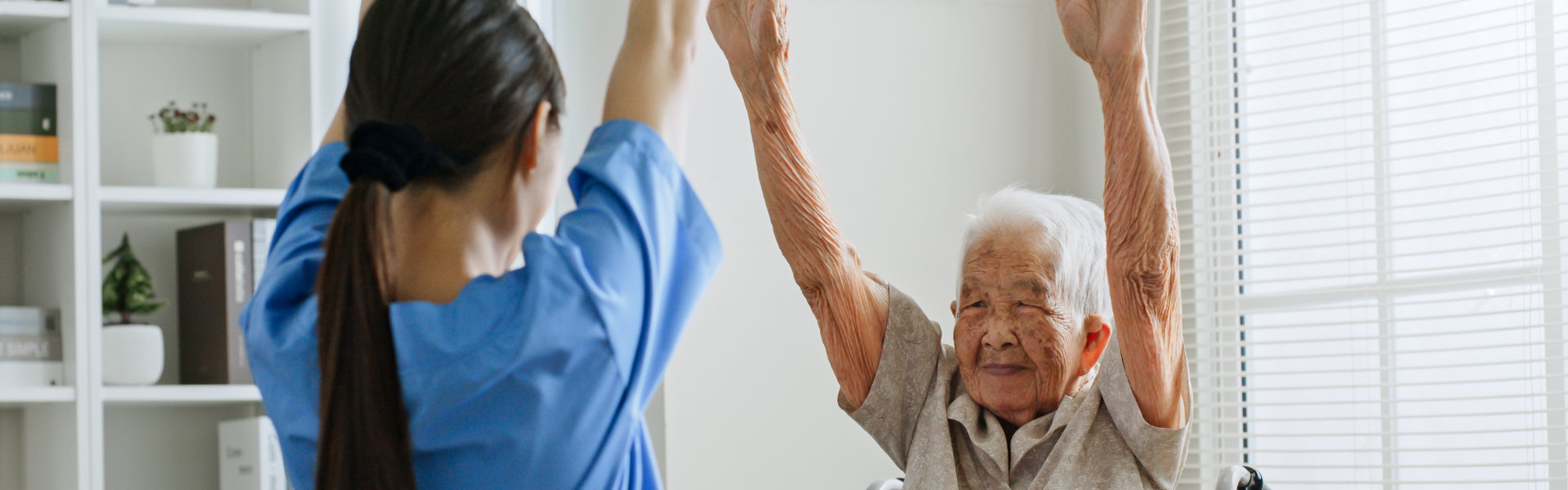 Nurse and senior woman are raising their hands